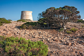 Fototapeta na wymiar Panoramic view of an ancient watchtower on the cliffs of Formentera in the Balearic Islands in Spain.
