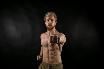 Beautiful muscles, athletic body. Studio photography on a black background, naughty light. Combat...