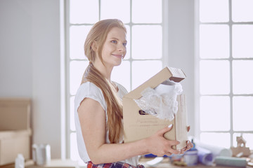 A beautiful single young woman unpacking boxes and moving into a new home