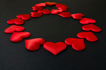 Digital symbol 8, laid out with red silk hearts on a black background. March 8. International Women's Day