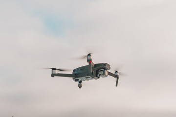 Running drone into the sky, quadcopter on blue sky background.