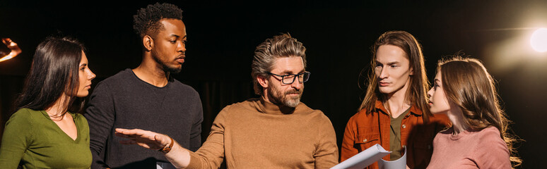 panoramic shot of multiethnic actors and actresses rehearsing with theater director on stage