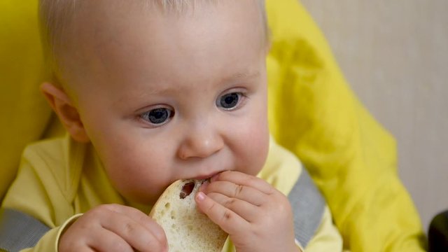 Small kid eating bread, close up.