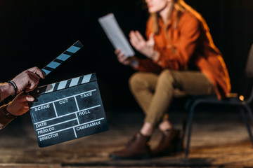 selective focus of actor with clapboard in front - obrazy, fototapety, plakaty