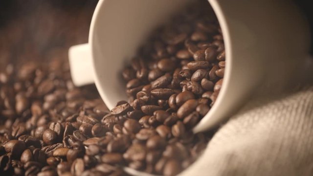 roasted arabica coffee beans with smoke and cup