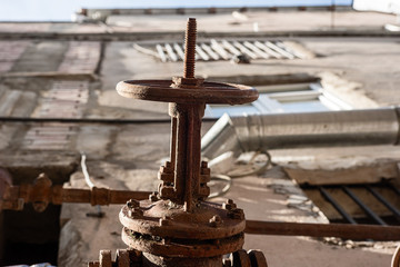 Rusty pipe with an old rusted valve from below