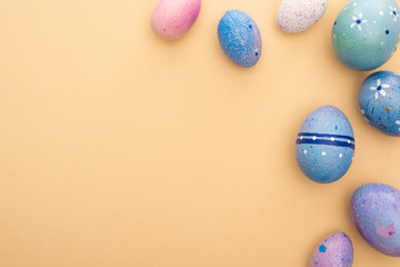Top view of Easter eggs on beige background