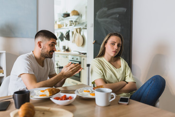 romantic couple arguing while having breakfast home