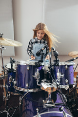 young girl playing drums at the music studio