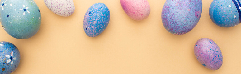 Top view of purple easter eggs on beige background, panoramic shot