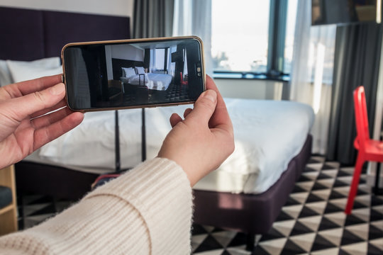 women's hands hold a smartphone and shoot the interior of a hotel room