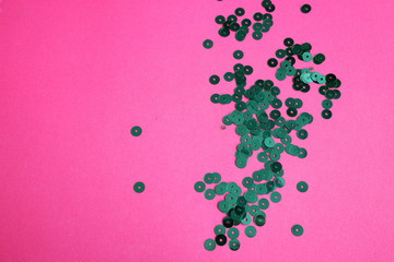 Juicy pink design background with green sequins. Festive background. Texture