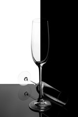 Two empty glasses of champagne with reflection, on a white and black gradient background. Club life concept.