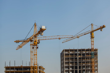 construction site with cranes against the blue sky	