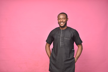 young handsome african man wearing african attire standing alone, smiling