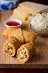 Egg rolls or spring rolls fried.Traditional Chinese Thai restaurant appetizer, spring rolls or egg rolls. Made from wonton wrappers and filled with Chinese veggies and served w/ chili dipping sauce.