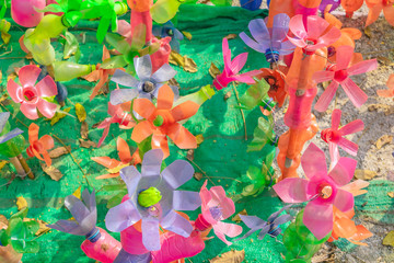 Recycled colorful plastic flowers made from plastic bottles to decorate as flowers in the garden. Plastic bottle recycled.