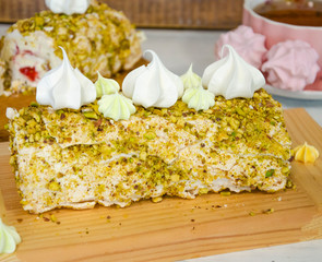 Pistachio merengue vanilla roll with strawberry confi on wooden plate