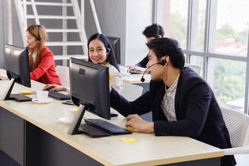 Asian call center employees working together at office. Concept for customer support service, office, employee.