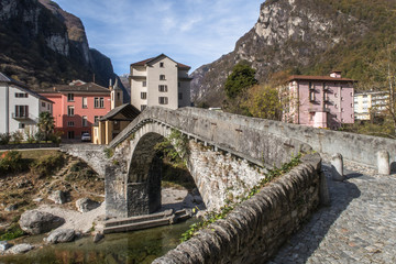 Fototapeta na wymiar BIGNASCO, SWITZERLAND - OCTOBER 24, 2017: A picturesque village in a valley Maggia, canton Ticino. Special are the ancient stone bridge and the church from 15th century.