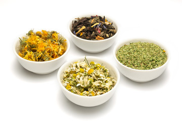 Four bowls with dried herbs (chamomile, calendula, fireweed and assorted herbs) isolated on white background. 
