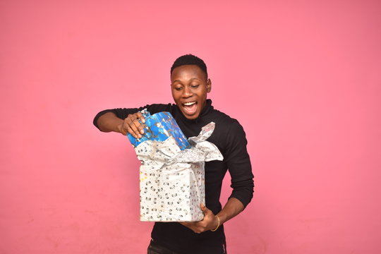 Handsome Young Black Man Opening A Gift Box Wrapped Feeling Happy And Excited