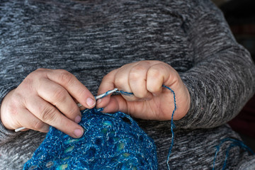 woman with crochet hook crochet and blue wool, hobby.