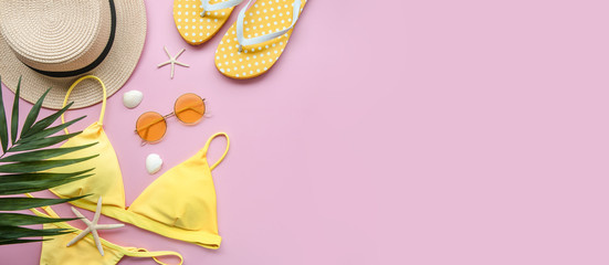 Flat lay yellow and pink colors summer beach concept. Bikini, straw hat, flip flops on pink background. Copy space for trip offers