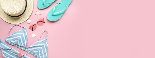 Top view female summer beach bikini, straw hat, flip flops and pink sunglasses on pink. Copy space for travel agency banner or shopping tour