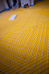 yellow underfloor heating installation with white pipes