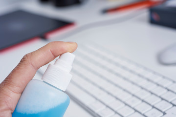 man disinfecting a computer keyboard