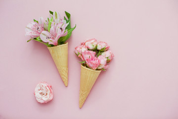 Ice cream cones with pink flowers on pink pastel background