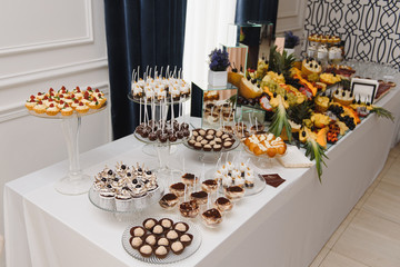 Delicious sweets on wedding candy buffet with desserts, cupcakes,tiramisu and cookies