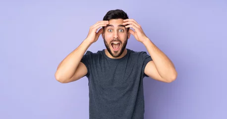 Deurstickers Caucasian handsome man with surprise expression over isolated purple background © luismolinero