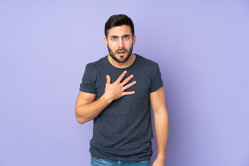 Caucasian handsome man pointing to oneself over isolated purple background