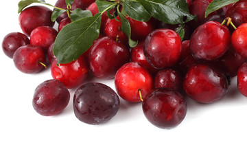 Red plums with leaves isolated on white