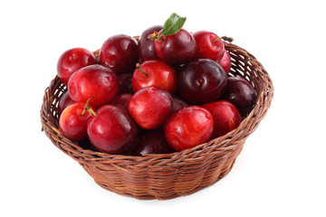Red plums on wicker plate