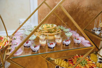 Delicious sweets on wedding candy buffet with desserts, cupcakes,tiramisu and cookies