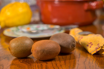 Fototapeta na wymiar Tres kiwis y varios limones sobre una mesa de madera
