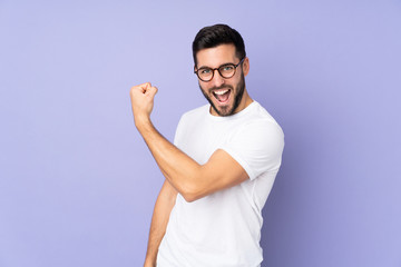 Caucasian handsome man over isolated background doing strong gesture