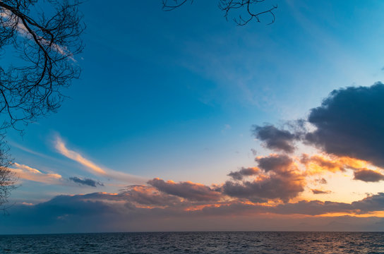 Beautiful landscape. Bright colorful sunset with dramatics clouds over the lake. 
