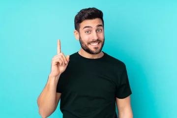 Foto op Plexiglas Caucasian handsome man isolated on blue background pointing with the index finger a great idea © luismolinero
