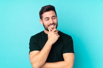 Caucasian handsome man isolated on blue background looking to the side