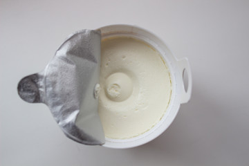 Cottage cheese in a container on a white background.
