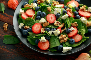 Spinach, Strawberry, blueberry salad with walnut and feta cheese. Summer healthy food