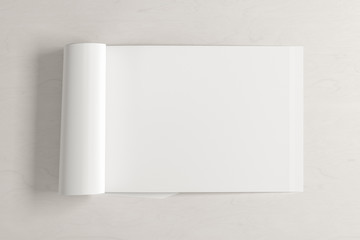 Blank horizontal right magazine page. Workspace with folded magazine mock up on white desk. View above. 3d illustration