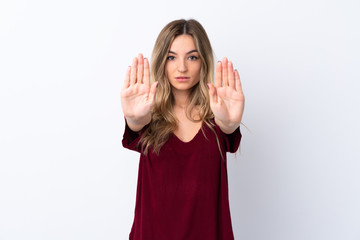 Young woman over isolated white background making stop gesture and disappointed