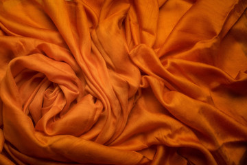 Orange wavy linen drapery, crumpled fabric.