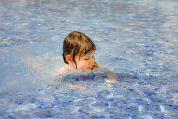 Fototapeta na wymiar portrait of a pretty little girl playing in a swimming pool