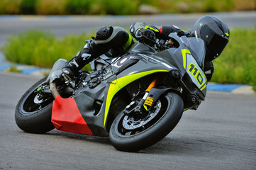 Motorcycle practice leaning into a fast corner on track